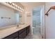 Well-lit bathroom with vanity, large mirror, and shower-tub combination with sliding glass doors at 6982 Rusty Nail Way, Las Vegas, NV 89119