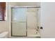 Bathroom tub with sliding glass doors and shower head, complemented by a window with wood blinds at 6982 Rusty Nail Way, Las Vegas, NV 89119