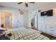 Bedroom featuring carpet, large bed with decorative pillows, storage bench and tv at 6982 Rusty Nail Way, Las Vegas, NV 89119