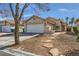Charming single-story home with a two-car garage, desert landscaping, and a welcoming entrance path at 6982 Rusty Nail Way, Las Vegas, NV 89119