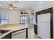 Bright kitchen featuring a white refrigerator, black cabinetry, and access to the backyard at 6982 Rusty Nail Way, Las Vegas, NV 89119