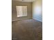 Neutral bedroom with beige carpet and natural light streaming through a window with blinds at 7439 S Pioneer Way, Las Vegas, NV 89113