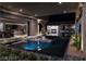 Modern backyard pool featuring a sunken lounge area surrounded by lush landscaping and ambient lighting at 751 Wexler Ct, Las Vegas, NV 89107