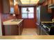 Functional kitchen featuring stainless steel appliances, wood cabinets, and a window for natural light at 774 Anne Ln, Henderson, NV 89015