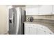 Bright kitchen featuring stainless steel refrigerator, white cabinets, and granite countertops at 7950 W Flamingo Rd # 2142, Las Vegas, NV 89147