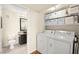Functional laundry area with washer, dryer, storage shelving and a nearby bathroom with toilet and sink at 7950 W Flamingo Rd # 2142, Las Vegas, NV 89147