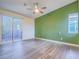 Bright bedroom with sliding glass door to patio, ceiling fan, and green accent wall at 816 Stannard Ct, Henderson, NV 89052
