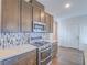 Kitchen with stainless steel range, microwave, wood cabinets, and contrasting countertop at 816 Stannard Ct, Henderson, NV 89052