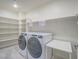 Well-lit laundry room with modern appliances and built-in shelving at 816 Stannard Ct, Henderson, NV 89052