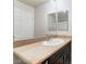 Bathroom vanity with a dark brown cabinets, light countertop and large mirror at 8600 W Charleston Blvd # 1043, Las Vegas, NV 89117