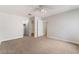 Spacious bedroom featuring neutral walls, plush carpet, fan, and multiple doorways at 8600 W Charleston Blvd # 1043, Las Vegas, NV 89117