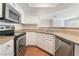 Corner kitchen featuring stainless appliances, granite countertops, and a view of living area at 8600 W Charleston Blvd # 1043, Las Vegas, NV 89117