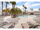 Community pool area surrounded by lounge chairs, palm trees, and a rock waterfall feature at 8600 W Charleston Blvd # 1043, Las Vegas, NV 89117