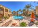 Community pool with ample seating surrounded by lush landscaping and multi-story residential buildings at 8777 W Maule Ave # 3090, Las Vegas, NV 89148