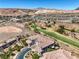 Aerial view of a stunning home with a golf course, mountain views, and lush landscaping at 10 Via Visione # 103, Henderson, NV 89011