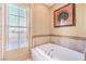 A soaking tub in a well-lit bathroom with tiled accents at 10 Via Visione # 103, Henderson, NV 89011