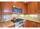 Gourmet kitchen featuring stainless steel appliances, granite countertops and tiled backsplash at 10 Via Visione # 103, Henderson, NV 89011