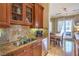 Modern kitchen with stainless steel appliances, granite counters, and open dining area at 10 Via Visione # 103, Henderson, NV 89011