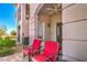 Inviting outdoor seating area with comfortable red chairs, perfect for relaxing and enjoying the view at 10 Via Visione # 103, Henderson, NV 89011