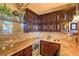 Elegant wet bar featuring custom cabinetry, granite countertops, sink, and wine refrigerator at 10 Via Visione # 103, Henderson, NV 89011