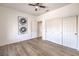 Bedroom with laminate floors, a ceiling fan, and a large closet, plus modern art on the walls at 10057 Bundella Dr, Las Vegas, NV 89134