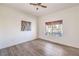 Simple bedroom with a ceiling fan, laminate floors and large windows looking out into the yard at 10057 Bundella Dr, Las Vegas, NV 89134