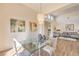 Dining area with a glass-top table, chandelier, and view into the living room, perfect for entertaining at 10057 Bundella Dr, Las Vegas, NV 89134