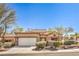 Charming single-story home with a neutral color scheme, tile roof, manicured landscaping, and an attached two-car garage at 10057 Bundella Dr, Las Vegas, NV 89134