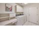 Functional laundry room includes washer, dryer, cabinetry, and counter space for folding and storage at 10057 Bundella Dr, Las Vegas, NV 89134