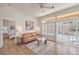 Cozy sitting room featuring a leather sofa, plantation shutters, and access to a bedroom at 10057 Bundella Dr, Las Vegas, NV 89134