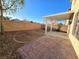 Backyard with brick patio and pergola adjacent to dirt yard at 11763 Village Arbor St, Las Vegas, NV 89183