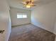 Neutral carpet and large window enhance this cozy bedroom with a ceiling fan at 11763 Village Arbor St, Las Vegas, NV 89183