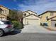 Two-story home featuring a two-car garage, neutral stucco and desert landscaping in a residential neighborhood at 11763 Village Arbor St, Las Vegas, NV 89183