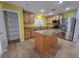 Kitchen featuring granite countertops, a center island, wood cabinets, and stainless steel appliances at 11763 Village Arbor St, Las Vegas, NV 89183