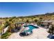 Enjoy a panoramic aerial view of the pool, spa, covered seating, lush landscaping, and green golf course at 18 Grand Corniche Dr, Henderson, NV 89011