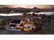 Stunning aerial view shows a large home with a pool, outdoor living area, lake, and mountain views at 18 Grand Corniche Dr, Henderson, NV 89011
