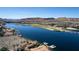 This aerial view showcases a community with a serene lake, lush golf course, and picturesque mountain backdrop at 18 Grand Corniche Dr, Henderson, NV 89011