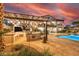 This expansive backyard features a full outdoor kitchen, a covered patio with string lights and a sparkling swimming pool at 18 Grand Corniche Dr, Henderson, NV 89011