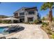 A spectacular backyard featuring a pool, lounge seating, spiral staircase, and desert landscaping at 18 Grand Corniche Dr, Henderson, NV 89011