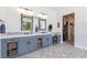Bathroom with double sinks, decorative mirrors, vanity seating, and stylish tile flooring at 18 Grand Corniche Dr, Henderson, NV 89011