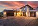 Stunning home at sunset, featuring a tile roof, a spacious three-car garage, and manicured landscaping at 18 Grand Corniche Dr, Henderson, NV 89011