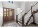 Bright foyer boasts a wooden front door, staircase, and decorative tile flooring at 18 Grand Corniche Dr, Henderson, NV 89011