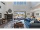 Comfortable living room with stone fireplace and views of the outdoor pool area at 18 Grand Corniche Dr, Henderson, NV 89011