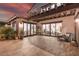Expansive backyard patio with tile flooring, large glass doors to the home, and manicured landscaping at 18 Grand Corniche Dr, Henderson, NV 89011