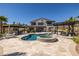 Backyard with a sparkling pool, spa, outdoor kitchen, and pergola at 18 Grand Corniche Dr, Henderson, NV 89011