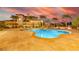 This gorgeous pool and spa are surrounded by travertine and feature an outdoor living space with string lights at 18 Grand Corniche Dr, Henderson, NV 89011