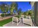 Landscaped backyard featuring a comfortable seating area, lush greenery, and a well-maintained lawn at 1900 Vero Dr, Las Vegas, NV 89134