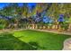 Lush backyard featuring artificial turf, mature trees, and a serene seating area, ideal for outdoor relaxation at 1900 Vero Dr, Las Vegas, NV 89134