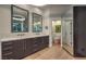 Modern bathroom with dual sinks, grey cabinets, and an open door to a private toilet room at 1900 Vero Dr, Las Vegas, NV 89134