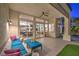 Comfortable covered patio with plush seating and a view into the home's interior, leading to a pool area at 1900 Vero Dr, Las Vegas, NV 89134